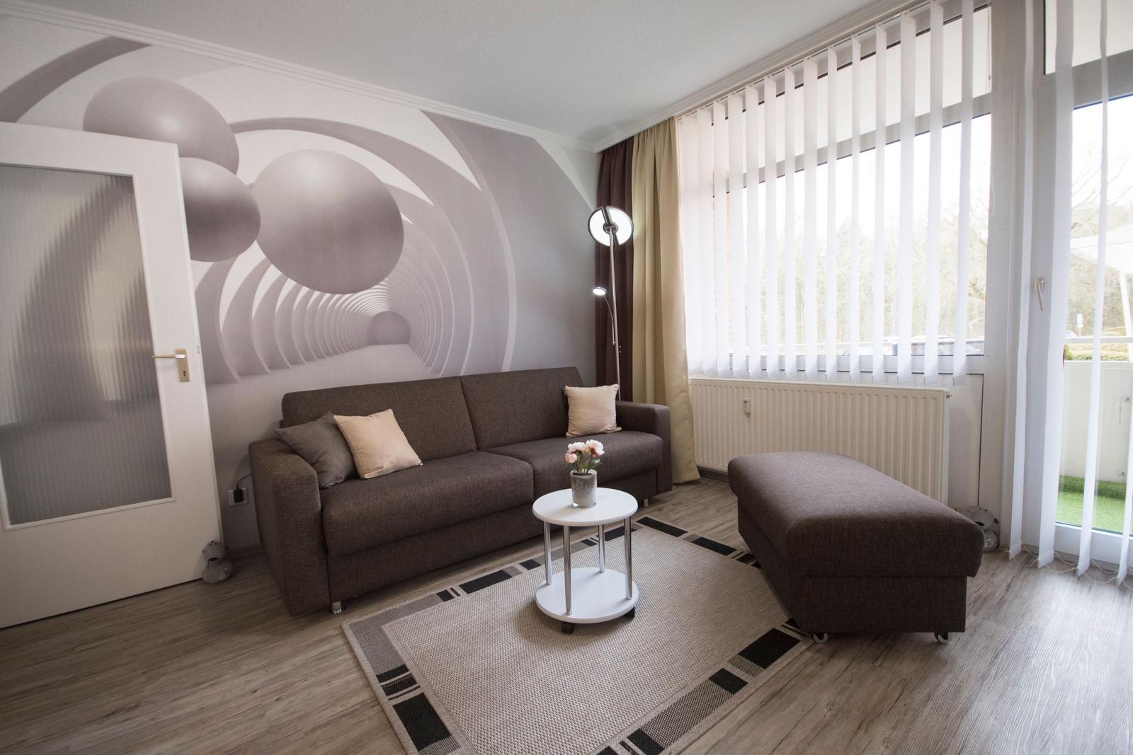 Wohnzimmer mit Sofa, Beistelltisch und Fenster mit Jalousien.