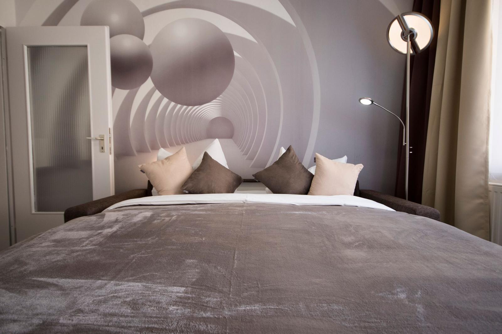 Ein Bett mit Kissen und einer Wanddekoration mit Kreisen.