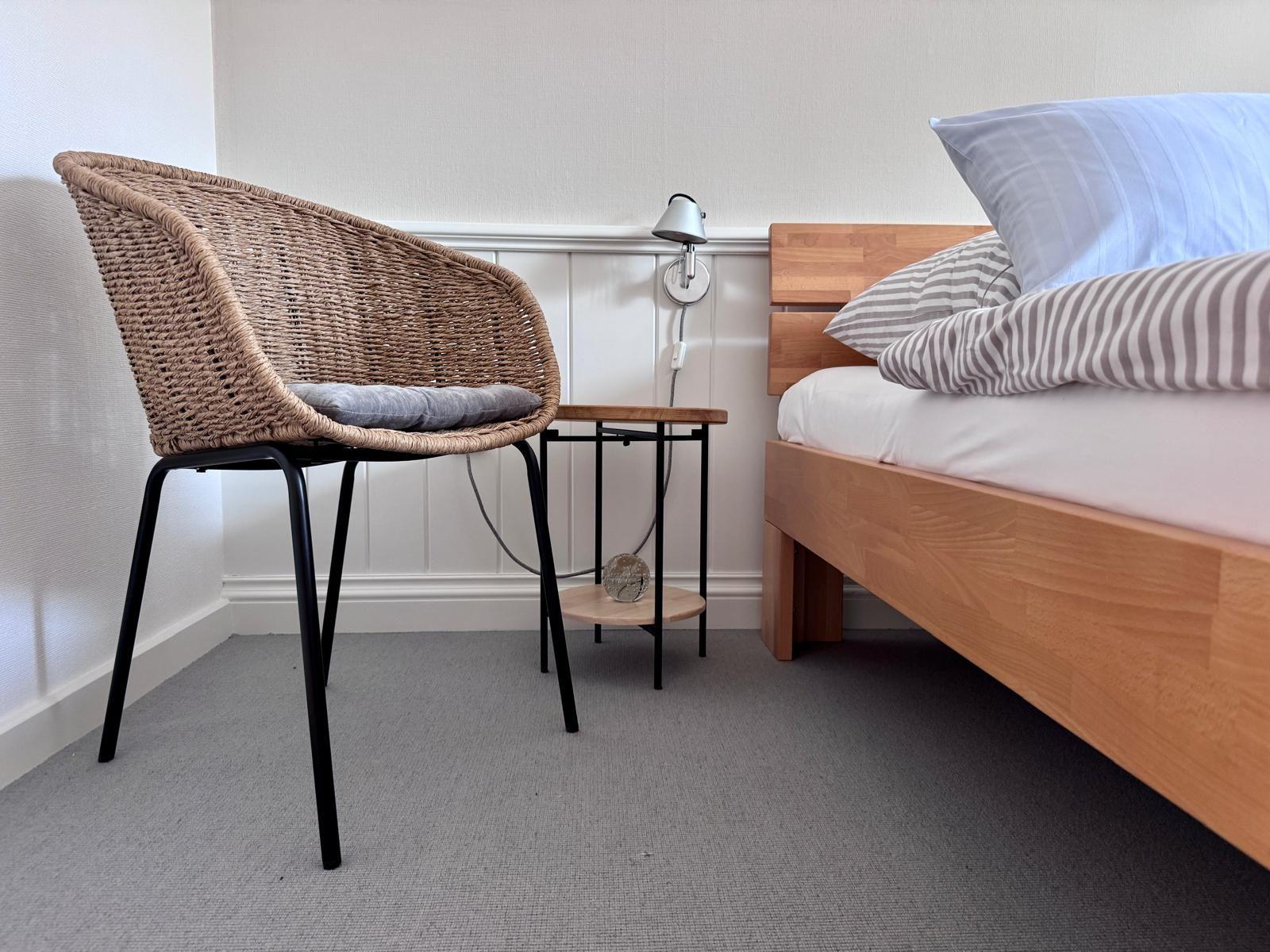 Schlafzimmer mit Bett, Stuhl und Nachttisch