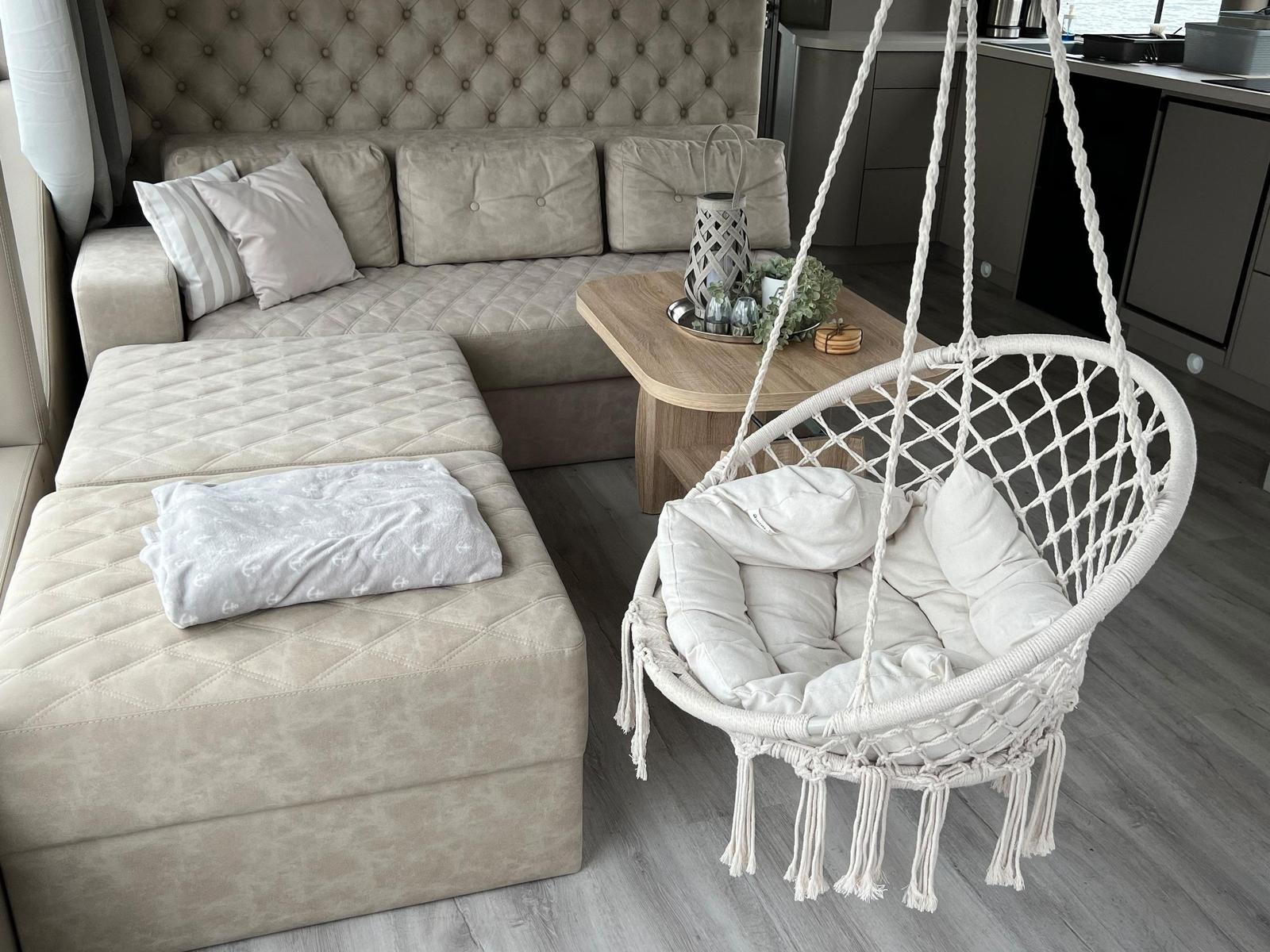 Ein Wohnbereich mit einem Sofa, einem Hängesessel und einem Couchtisch.