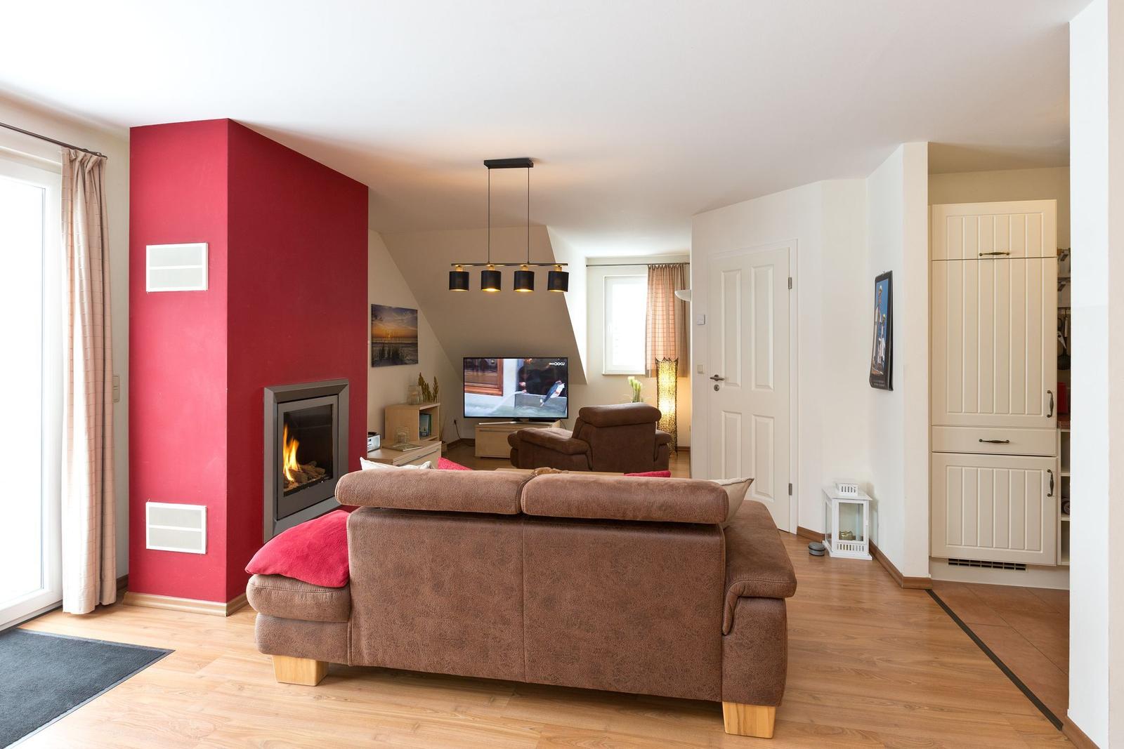 Wohnzimmer mit Sofa, Kamin und Fernseher