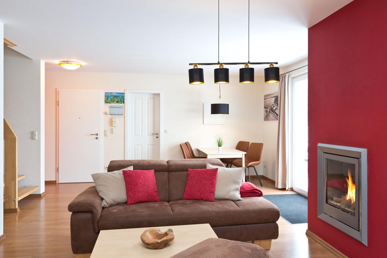 Wohnzimmer mit Sofa, Kamin und Essbereich