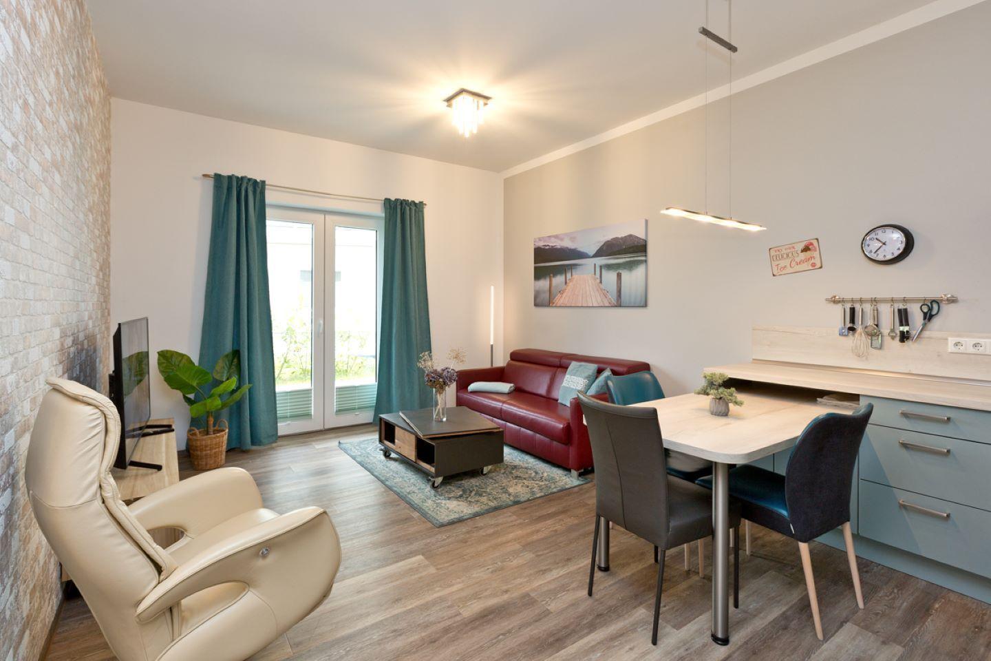 Wohn- und Essbereich mit Sofa, Esstisch und Fernseher.
