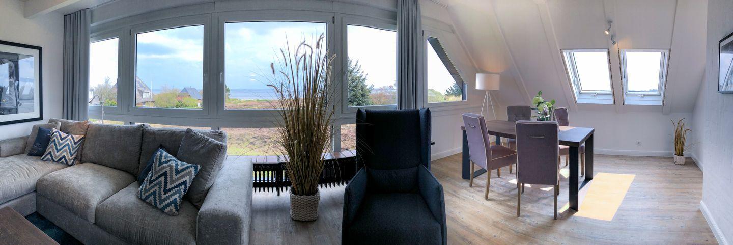 Living and dining area with large window and sea view.