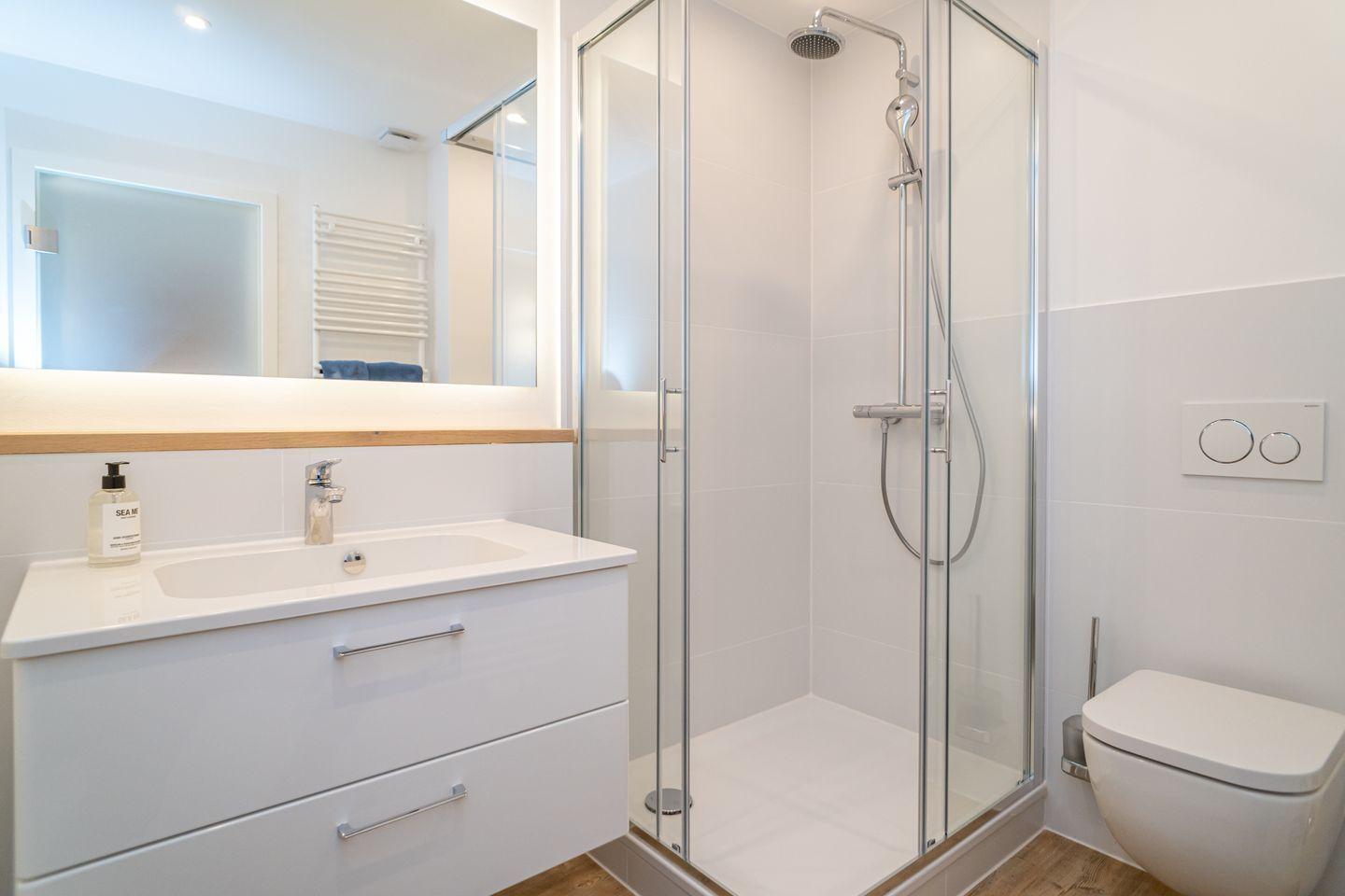 Modern bathroom with shower, sink, and toilet.