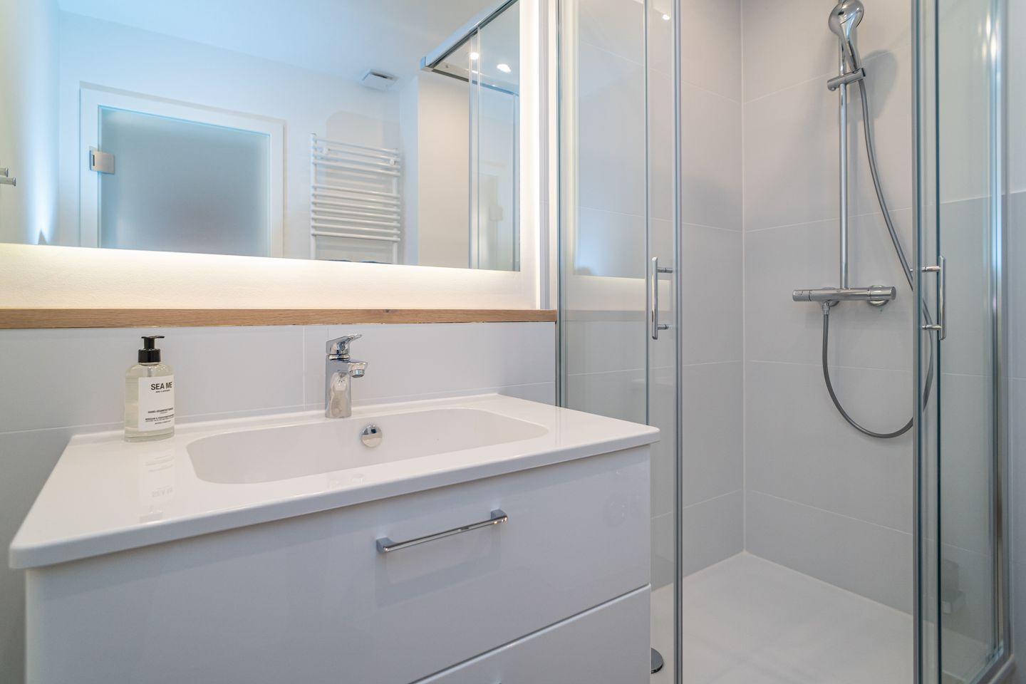 Bathroom with shower, sink, and mirror