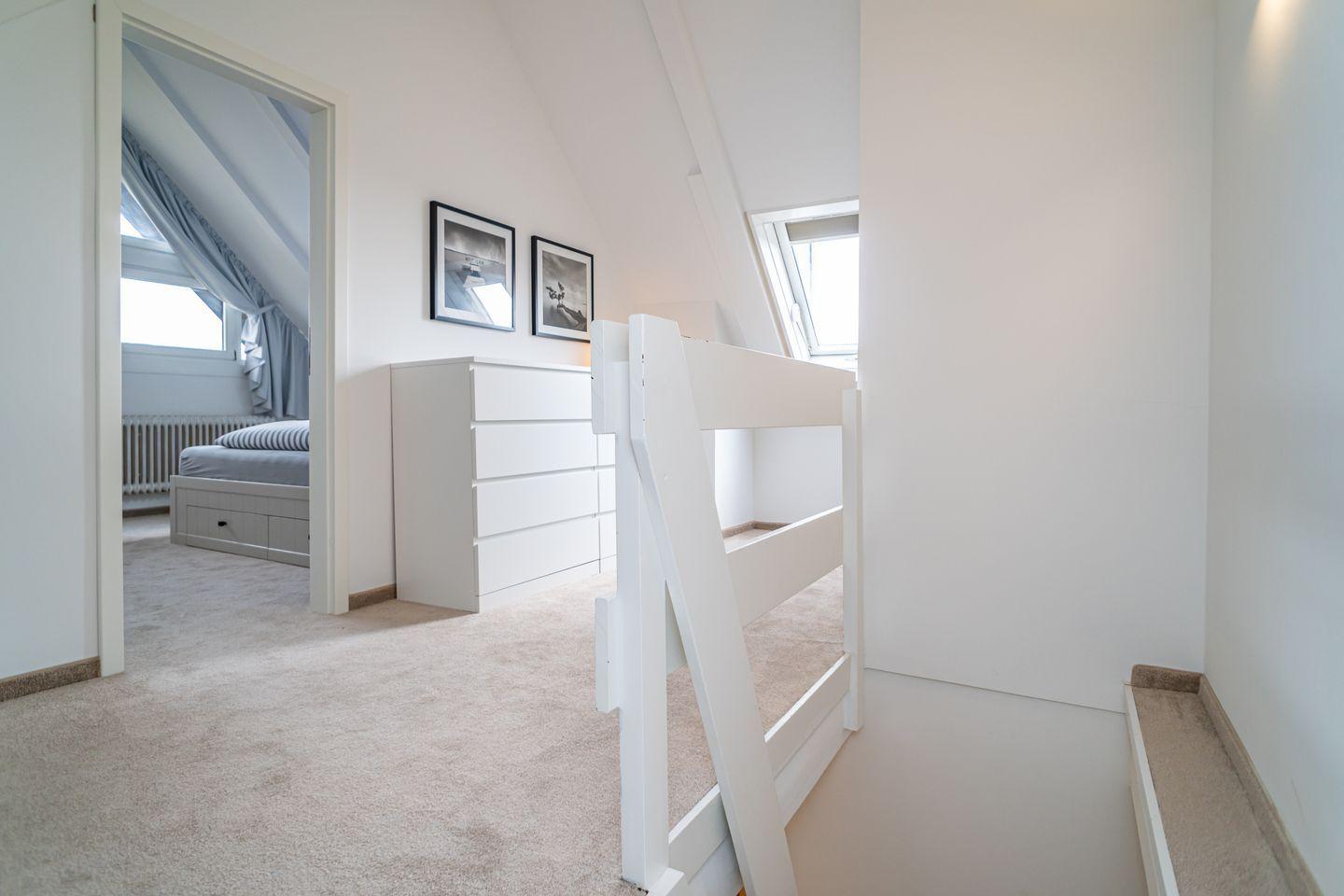 Bedroom with double bed and window. Adjacent room with white bunk bed and dresser.