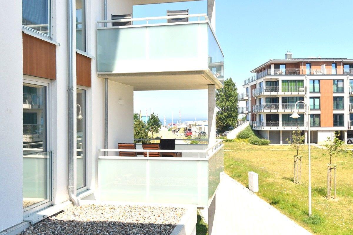 Terrasse mit Sitzgelegenheiten und Blick auf den Strand und das Meer.