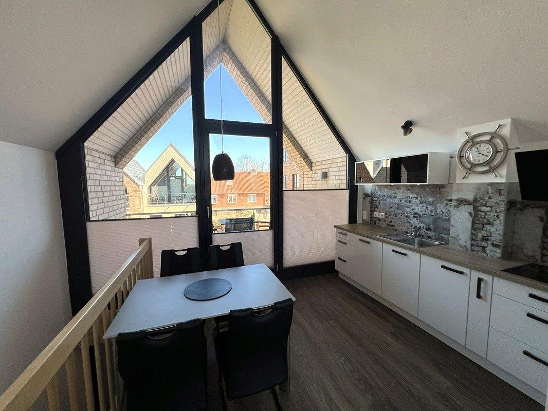Küche und Essbereich mit großem Fenster und Blick auf die Straße.
