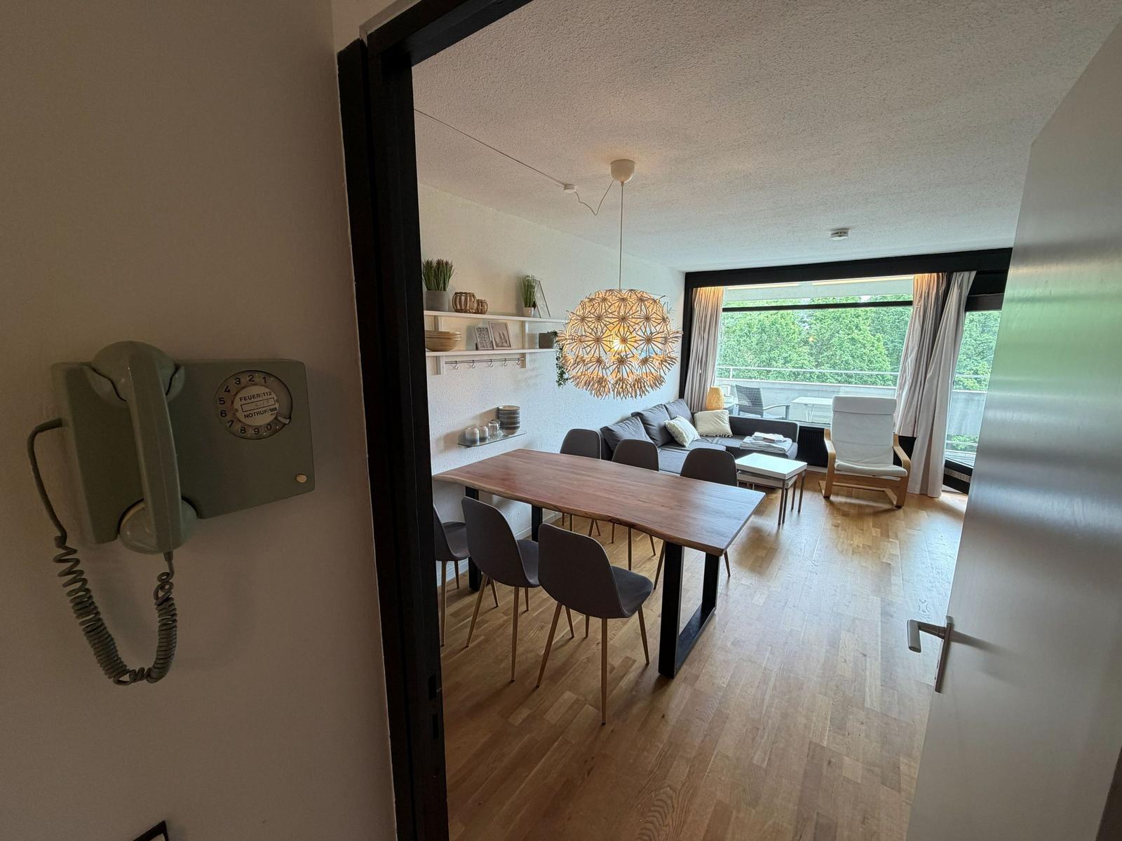 Ein Esszimmer mit Tisch und Stühlen, ein Wohnbereich mit Sofa und Balkon.