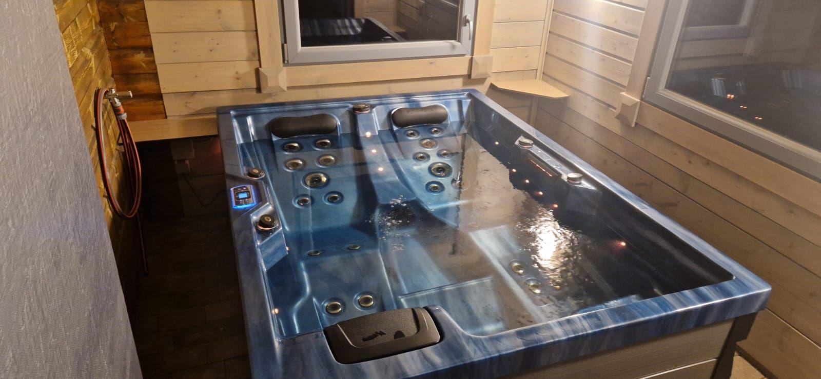 Ein blauer Whirlpool mit mehreren Massage Düsen und einem digitalen Steuerfeld.