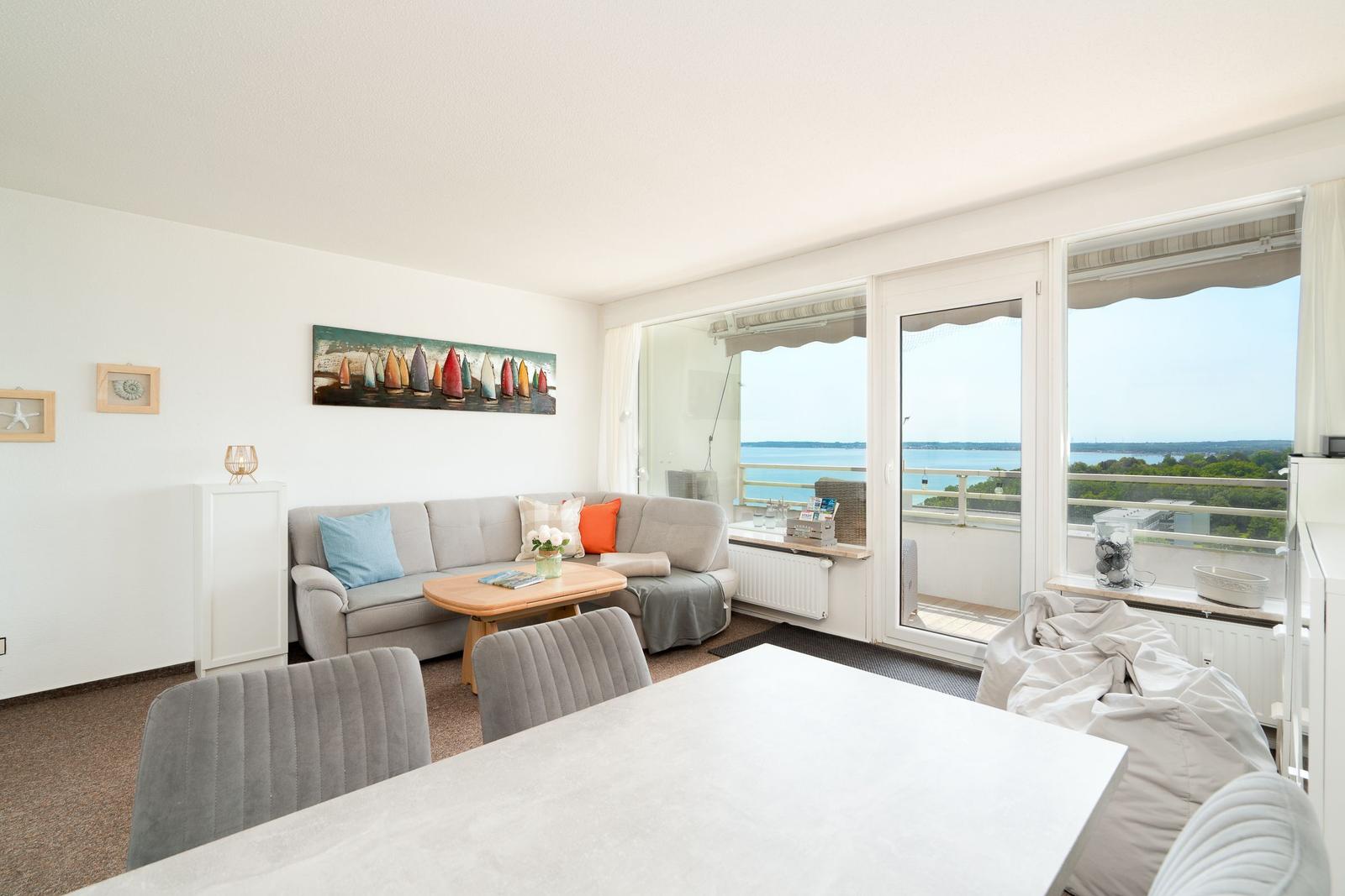 Wohn- und Essbereich mit Blick aufs Wasser und Balkon.