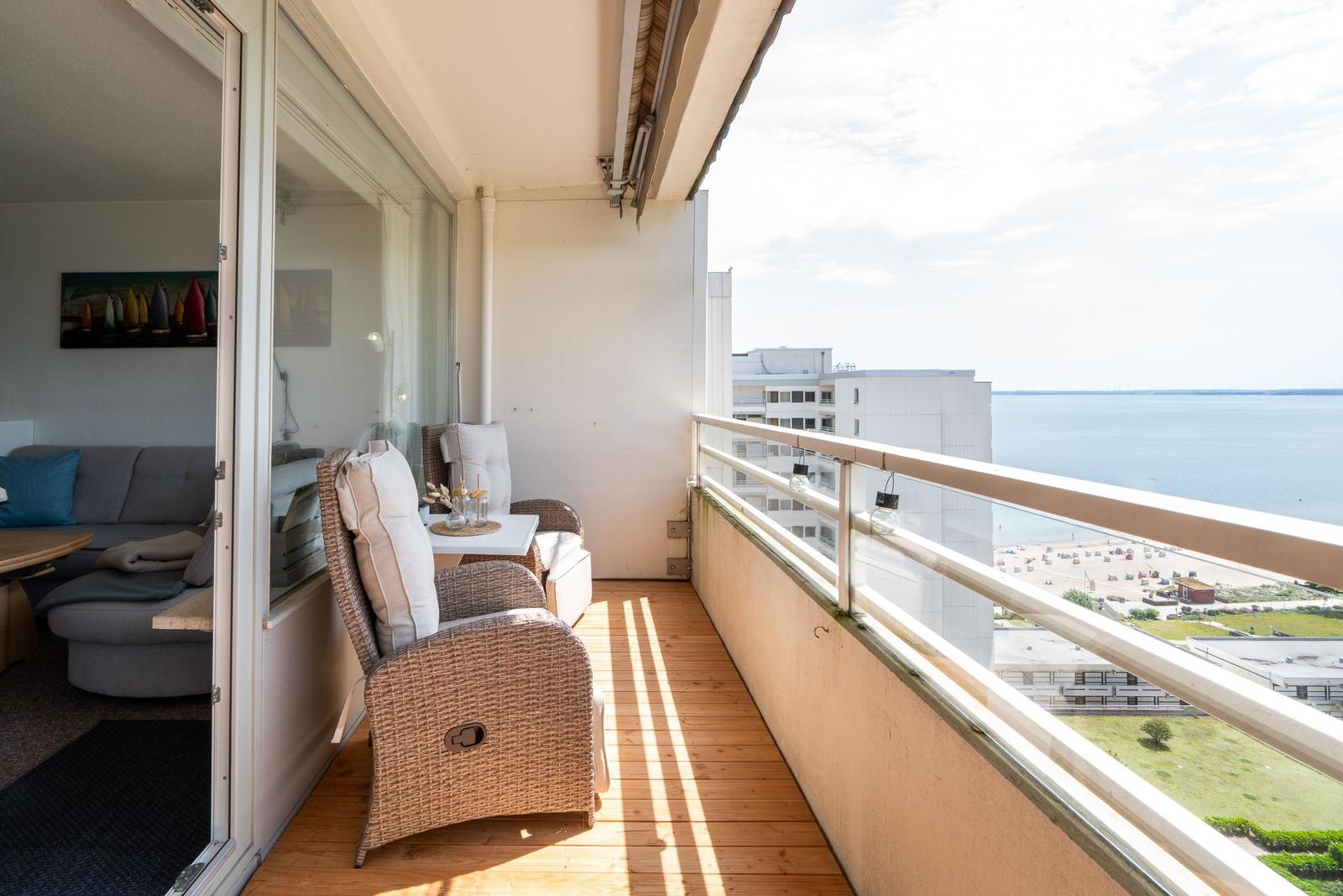 Balkon mit Sitzgelegenheiten und Blick aufs Meer und Strand.