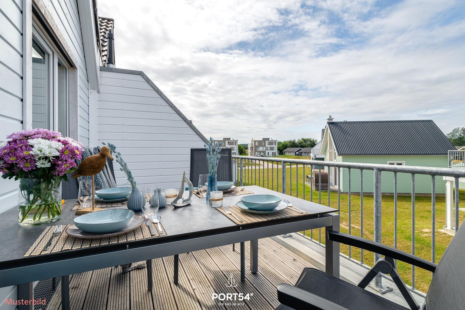 Terrasse mit gedecktem Tisch und Blick auf Grünflächen und Häuser