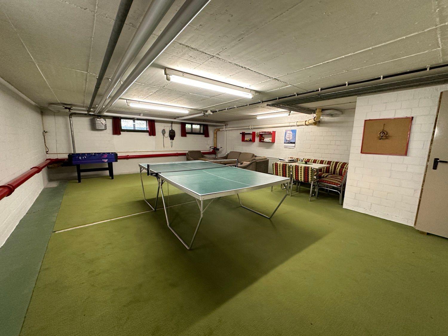 Raum mit Tischtennisplatte, Foosballtisch und Sitzgelegenheiten.