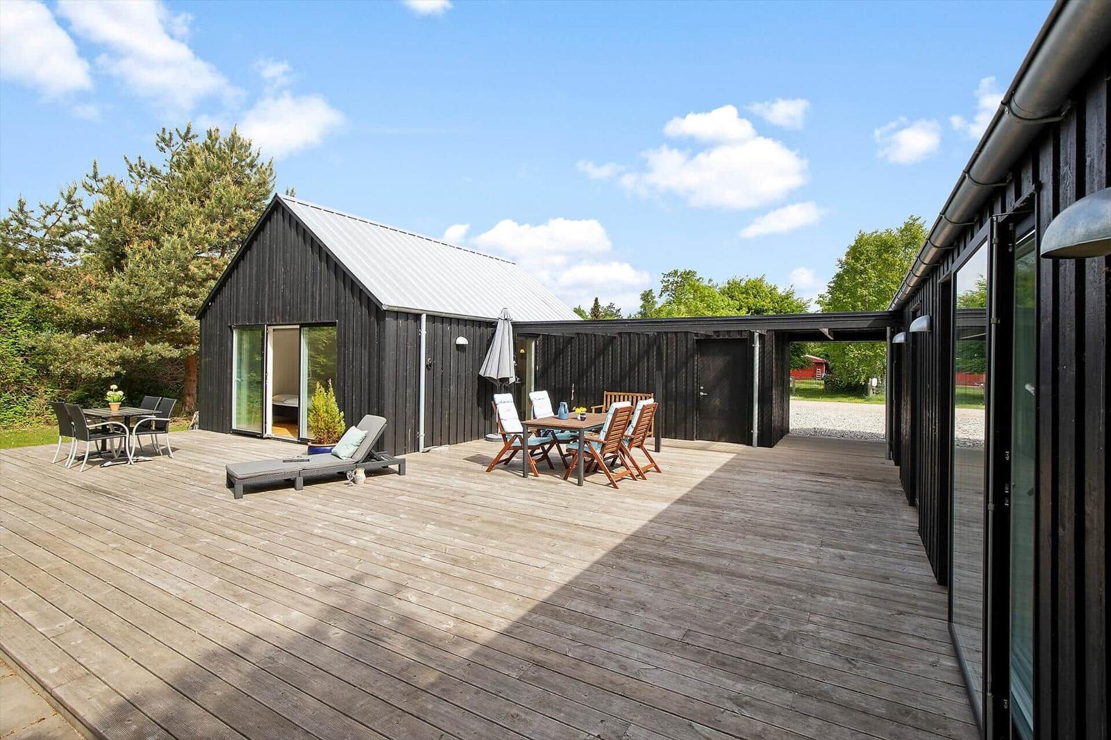 Große Terrasse mit Gartenmöbeln und Blick auf das Haus.
