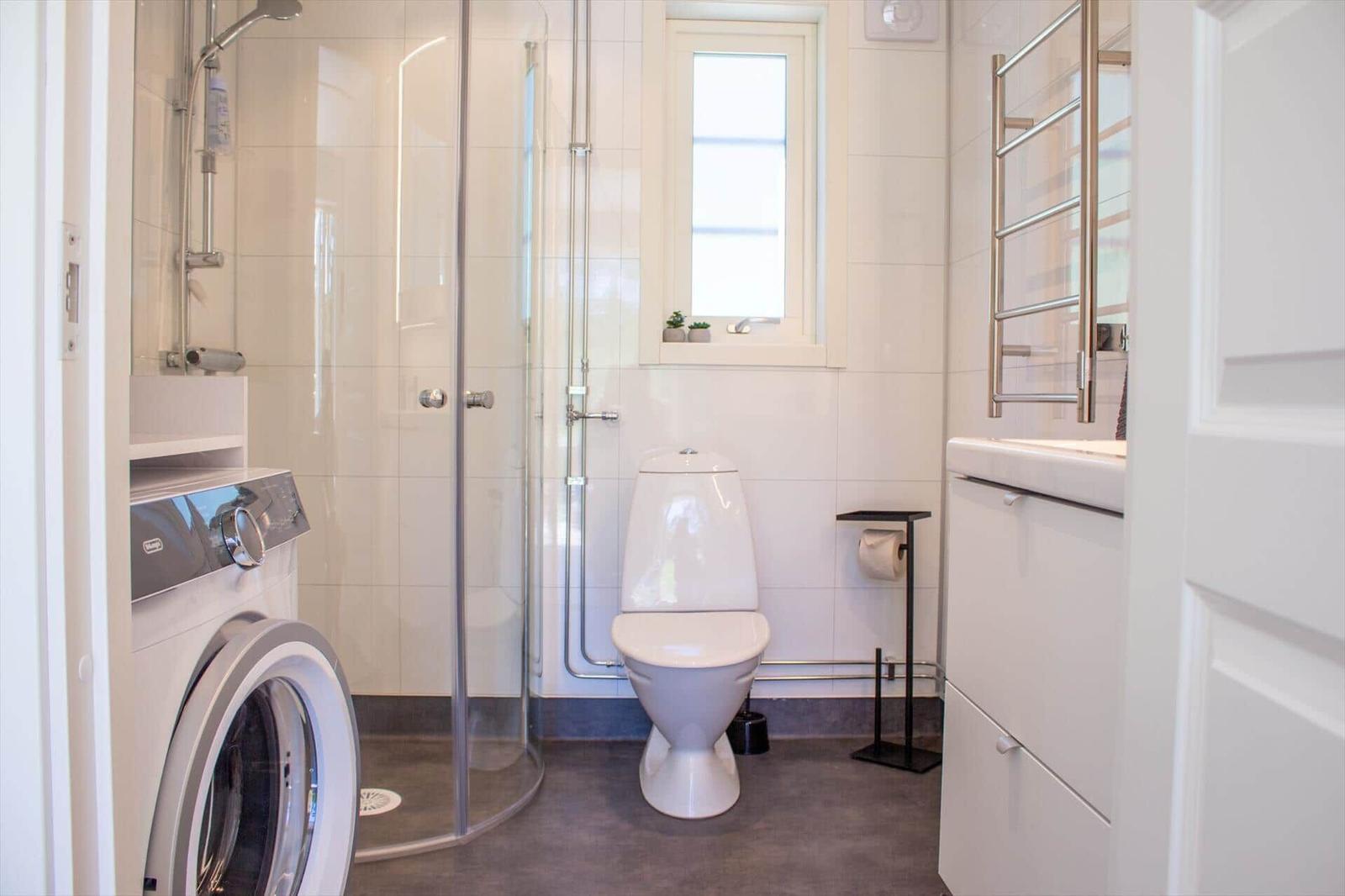 Badezimmer mit Dusche, Toilette und Waschmaschine