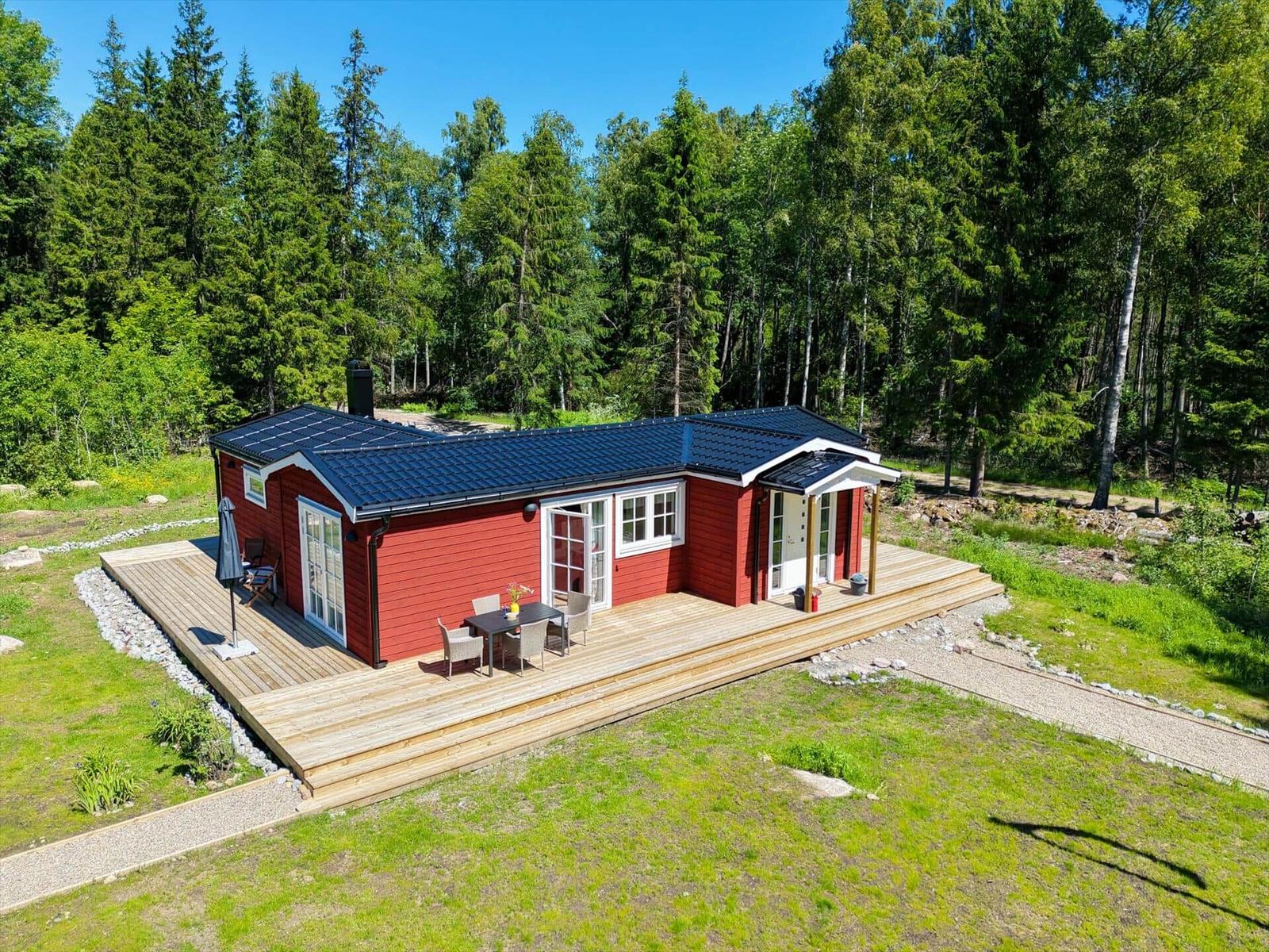 Rotes Ferienhaus mit Terrasse und Grillplatz im Wald