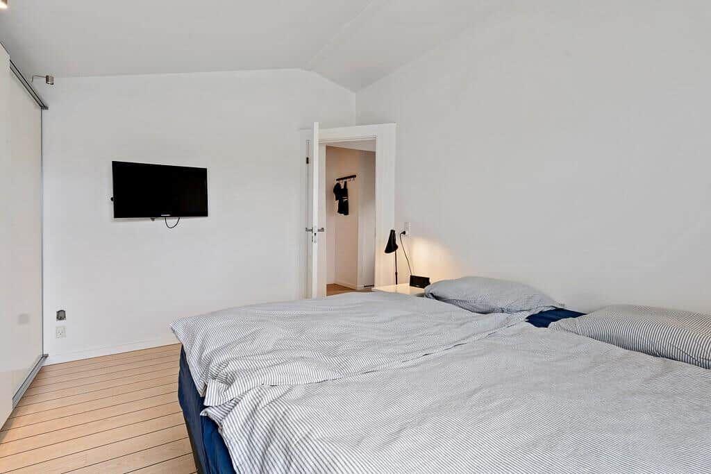 Schlafzimmer mit Bett, Fernseher und Kleiderhaken im Anschluss