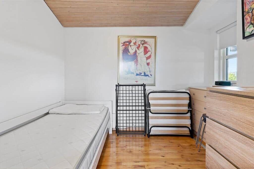 Schlafzimmer mit Matratze, Schlafwagen und Holzboden.