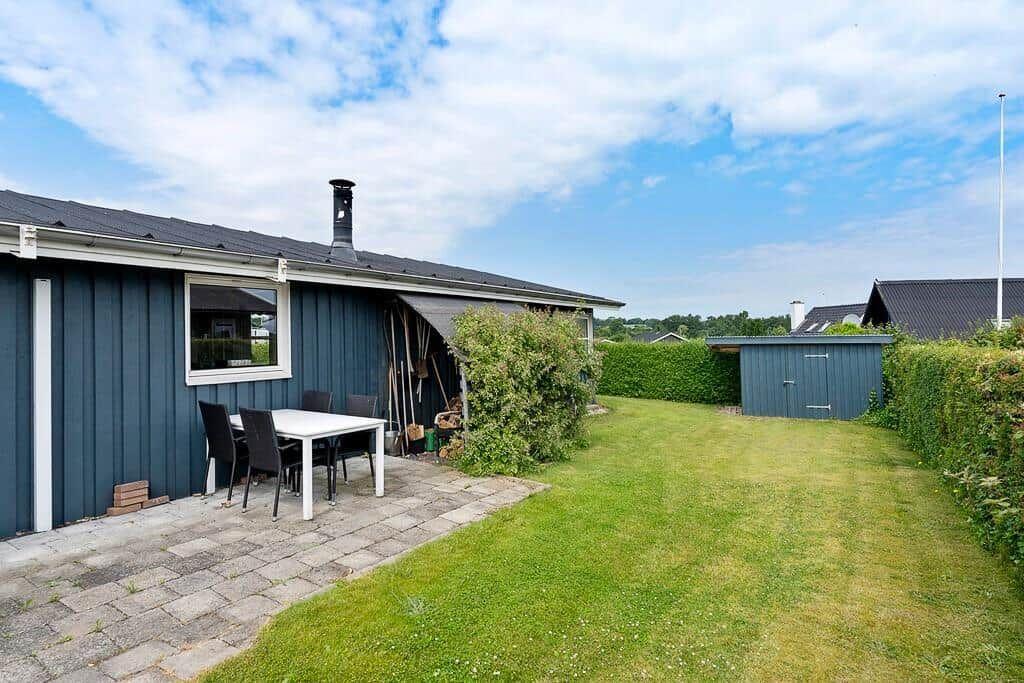 Ein blauer Ferienhaus mit Terrasse, Garten und Grillplatz.