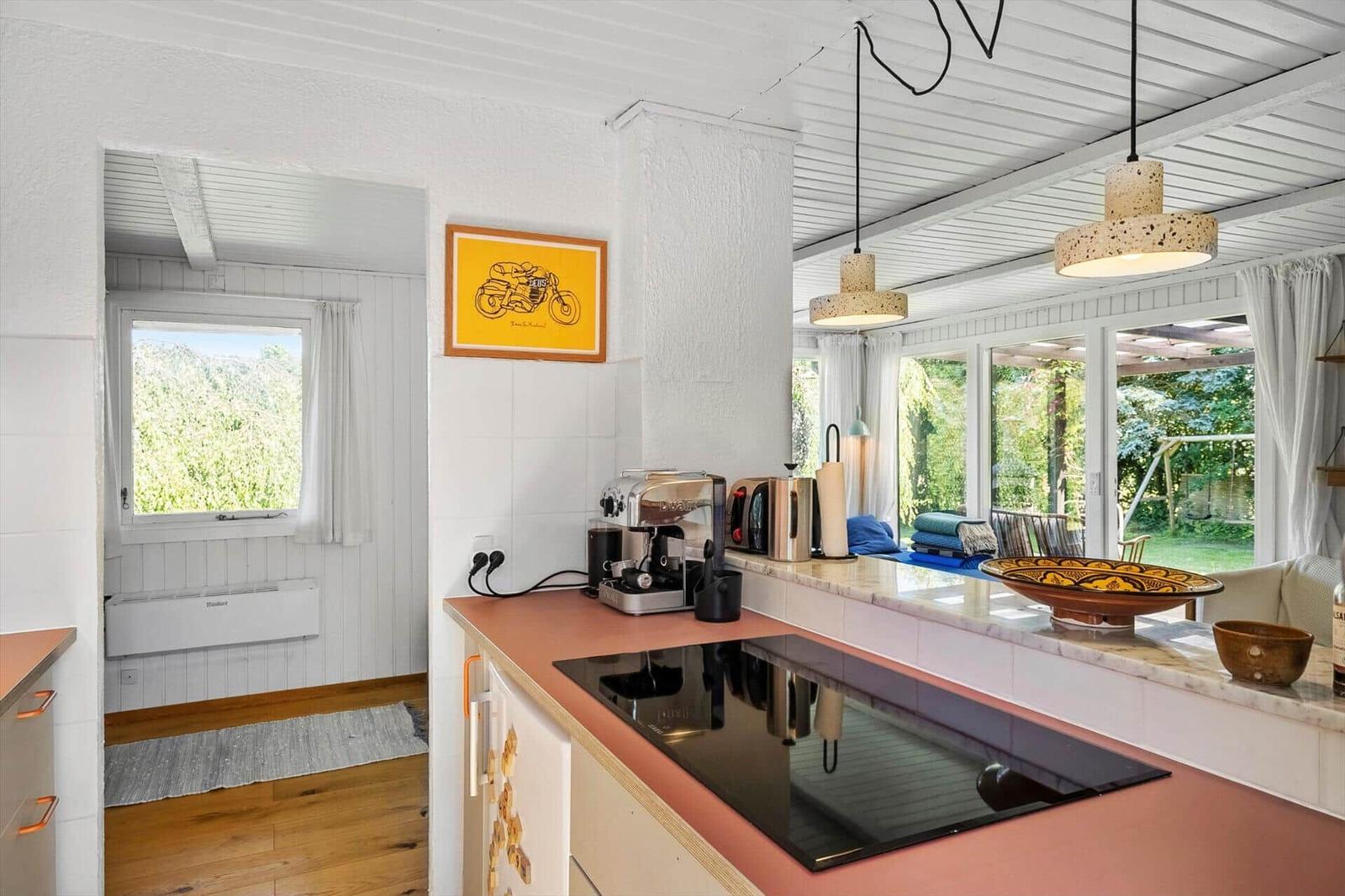 Küche mit Arbeitsplatte, Kaffeemaschine und Blick auf Garten
