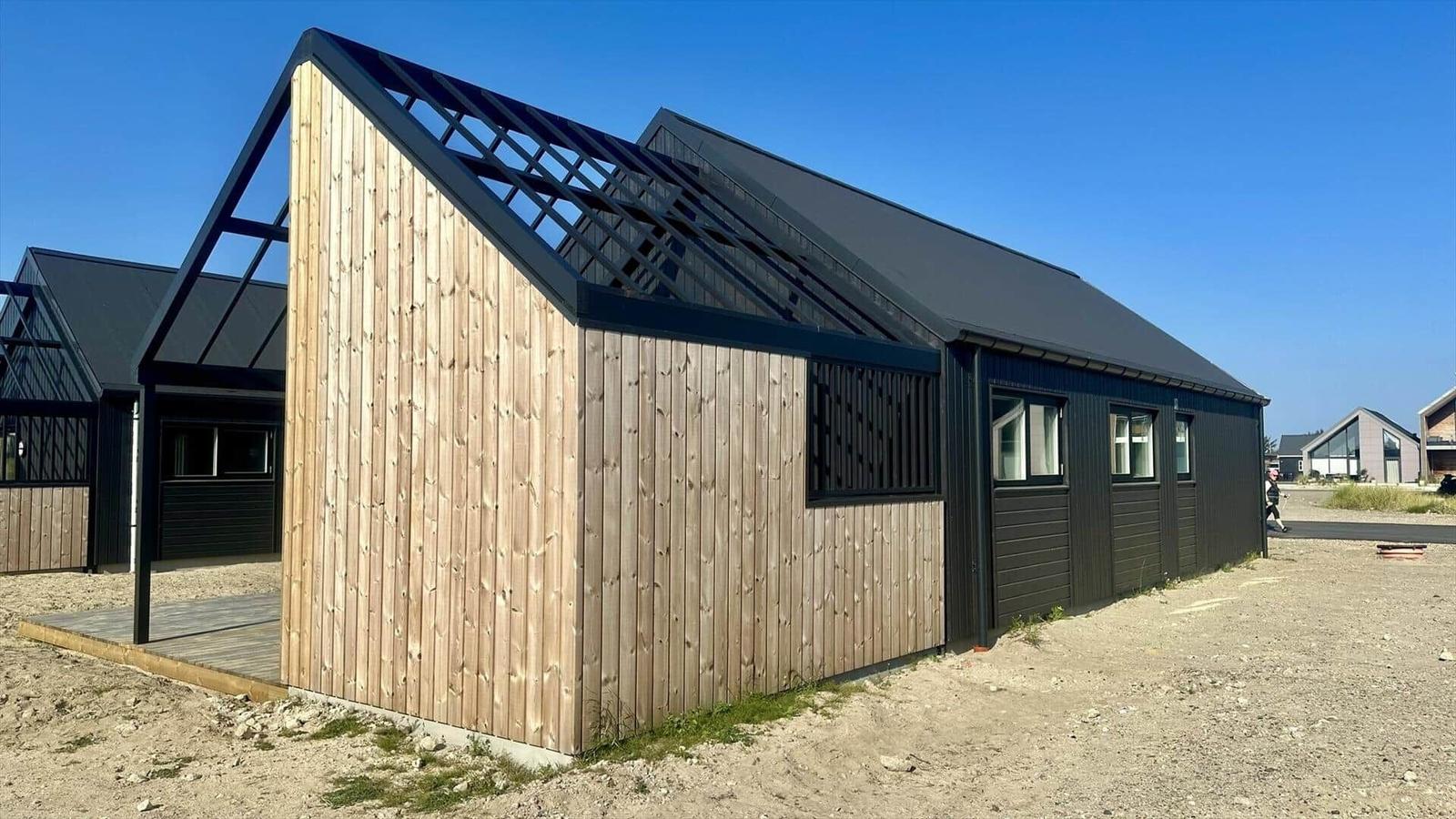 Moderne Holz- und Metallbauweise mit schrägen Dächern und Fenstern.