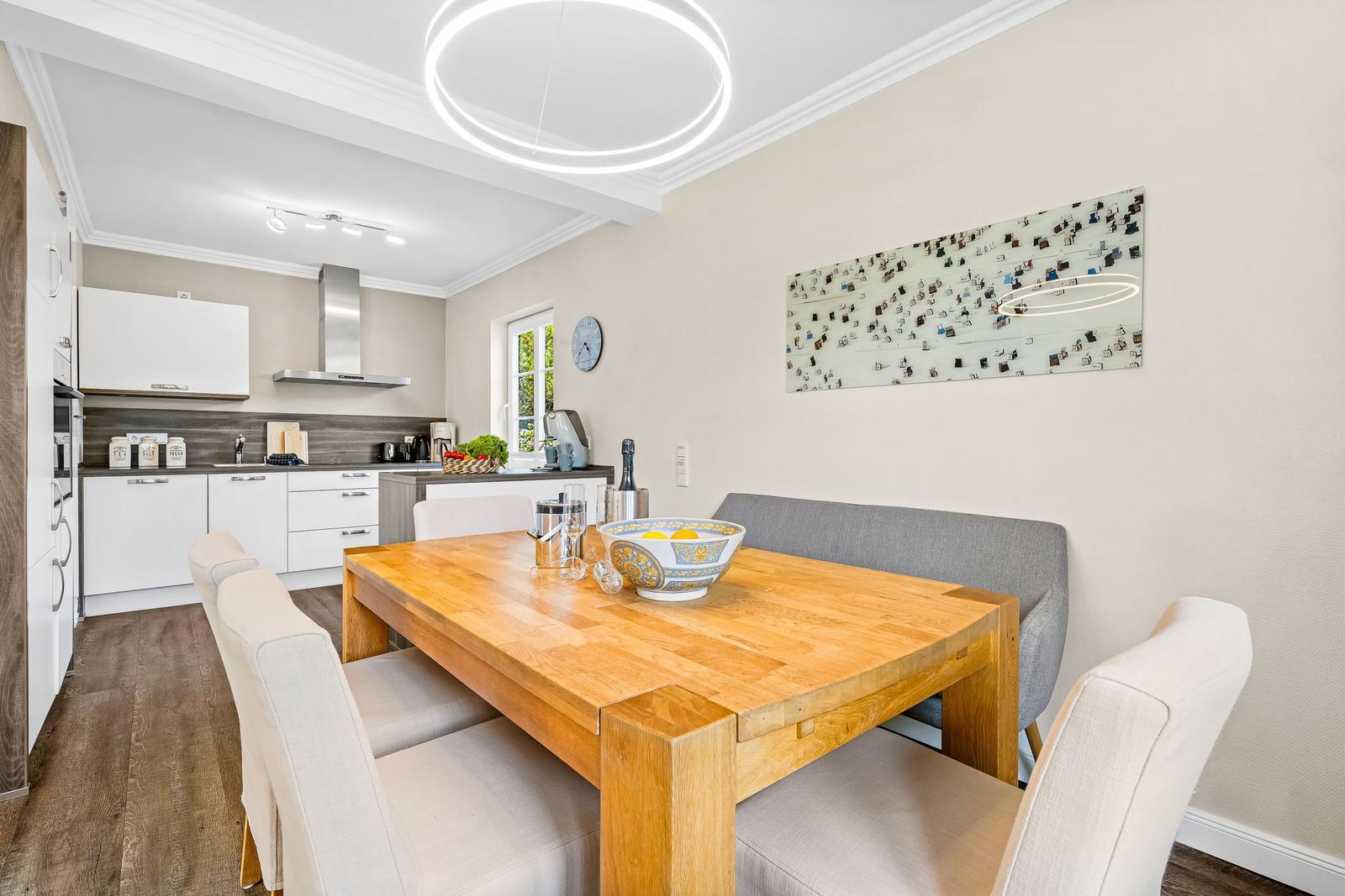 Dining area with wooden table and chairs, kitchen area in background.