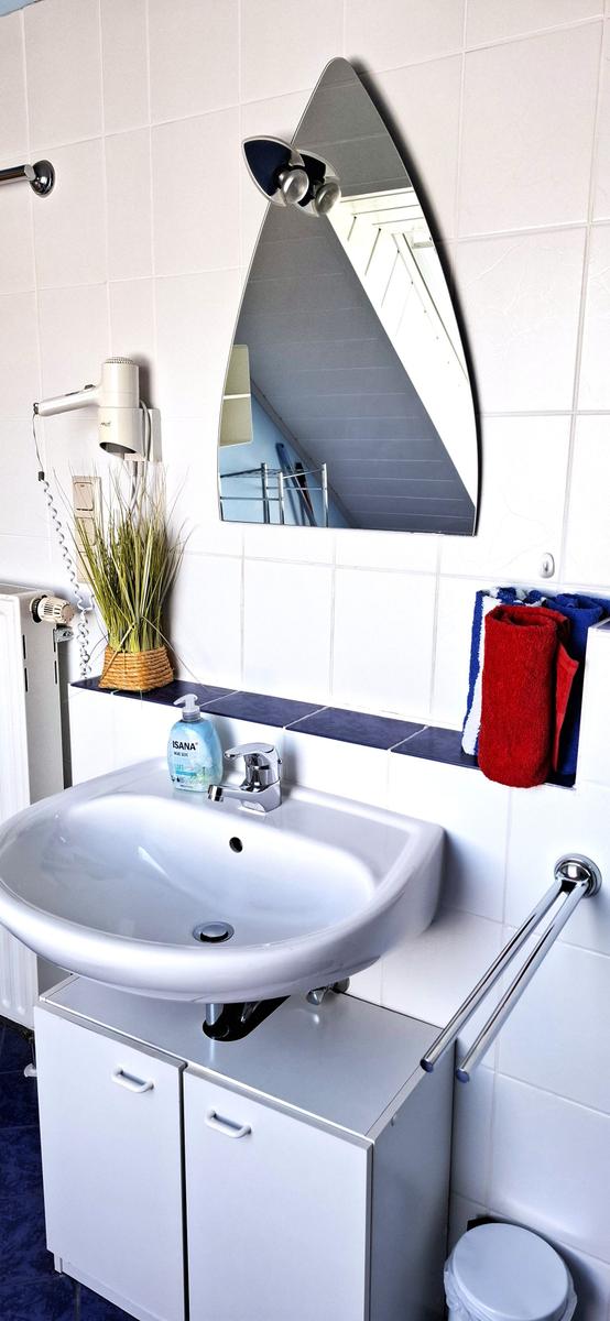 Badezimmer mit Waschbecken, Spiegel und Handtuchhalter