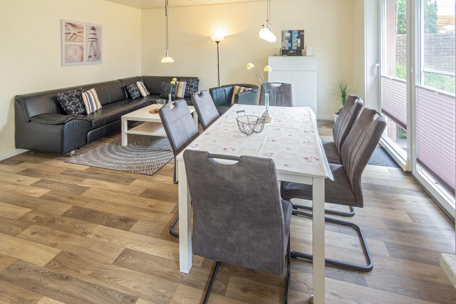 Esszimmer mit Tisch und Stühlen, Wohnbereich mit Sofa und Couchtisch