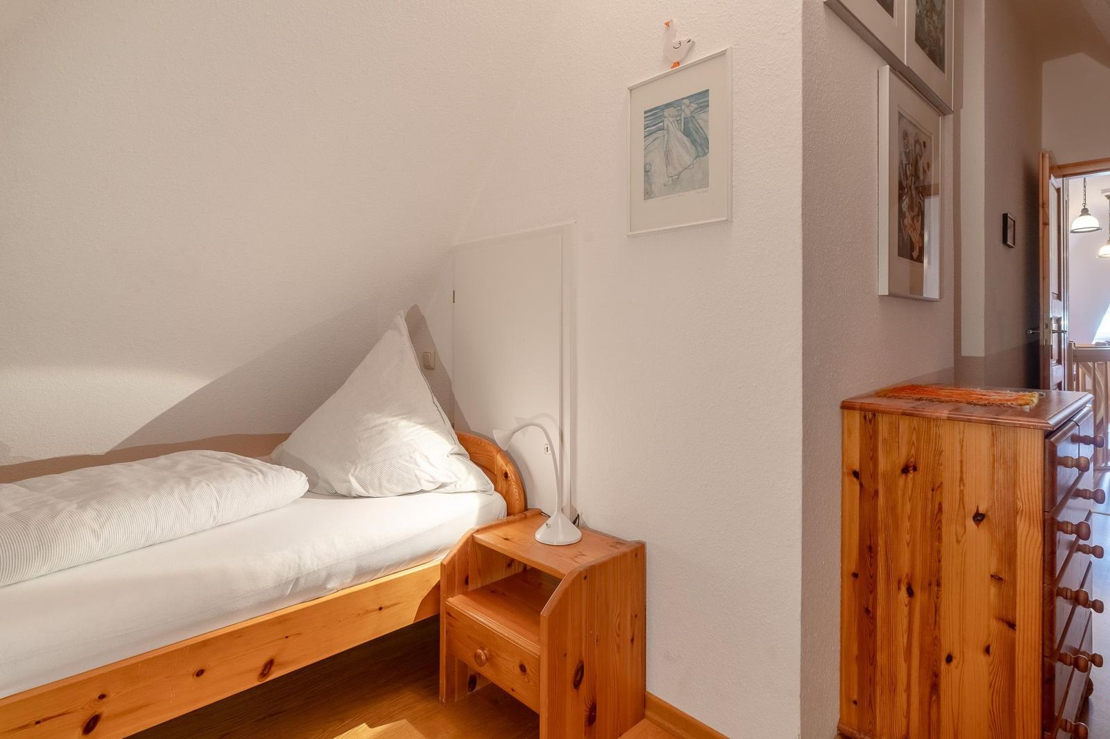 Ein Schlafzimmer mit einem Bett, Nachttisch und Schrank aus Holz.