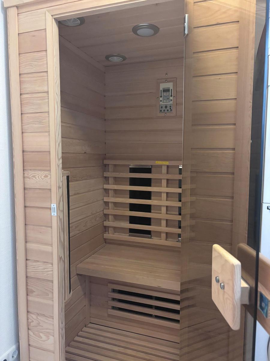 Sauna mit Holzwand, Sitzbank und Steuerung