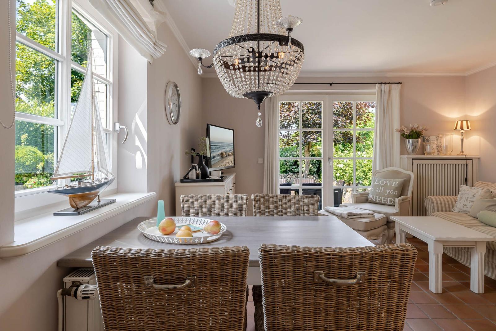 Essbereich mit Esstisch, Stühlen und Fensterblick. Wohnbereich mit Sofa und Beistelltisch.