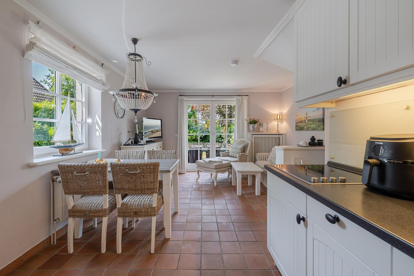 Küche, Essbereich und Wohnzimmer mit Terrassentür und Blick auf Garten.