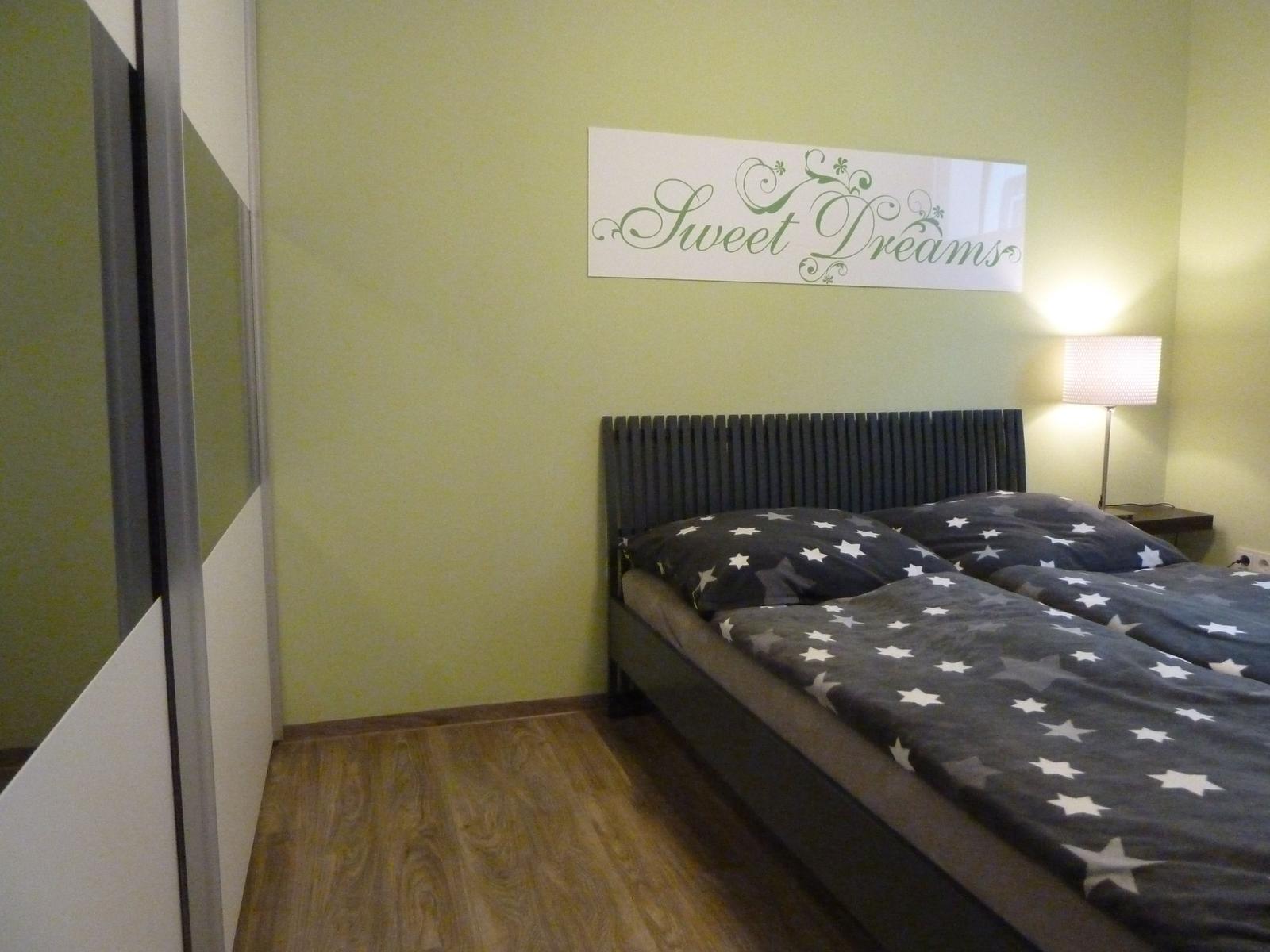 Schlafzimmer mit Bett, Wandbild und Nachttisch