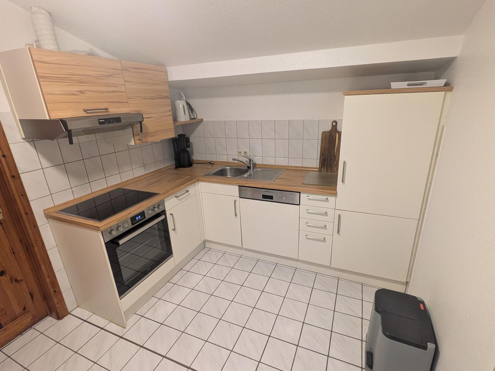 Küche mit Holz Arbeitsplatten, Spüle, Herd und Kühlschrank.