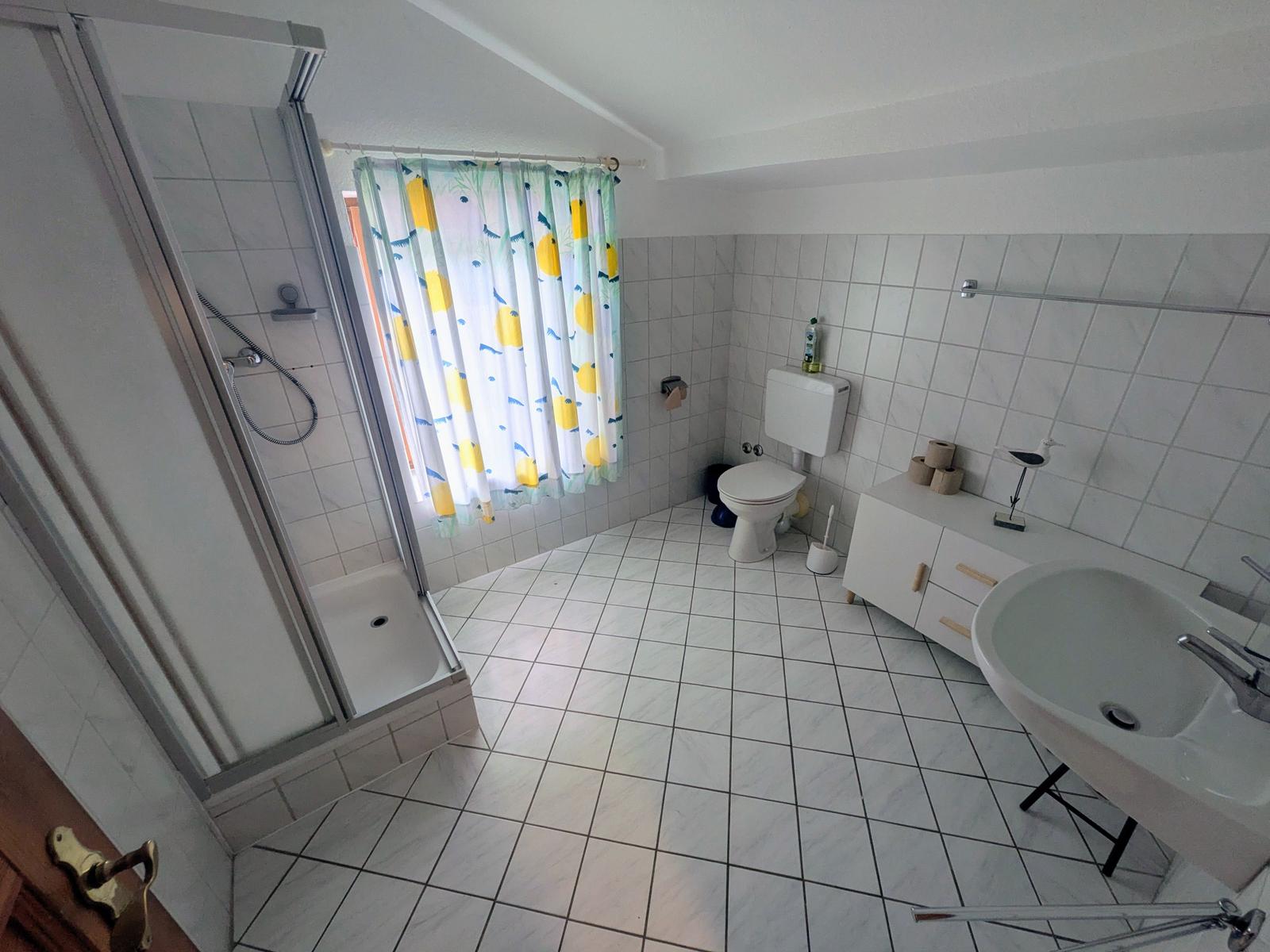 Badezimmer mit Dusche, Toilette und Waschbecken