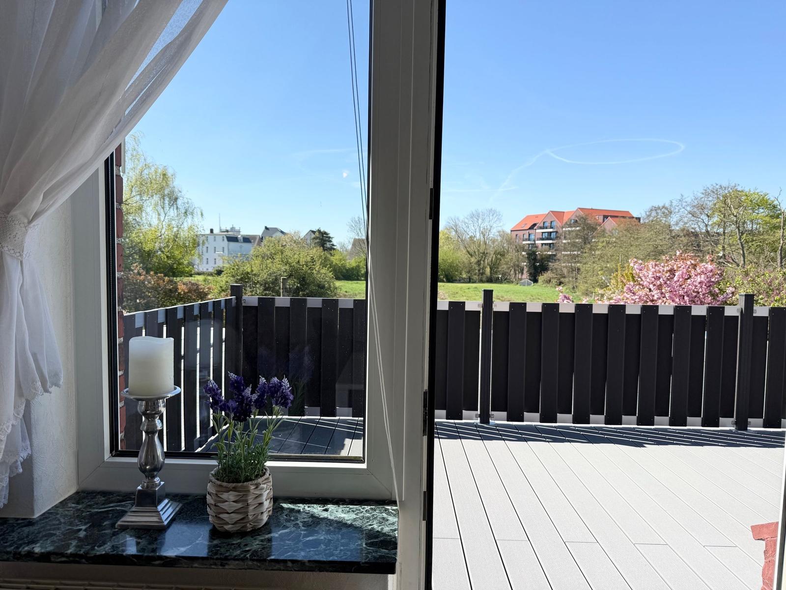 Terrasse mit Blick auf grüne Landschaft und Gebäude