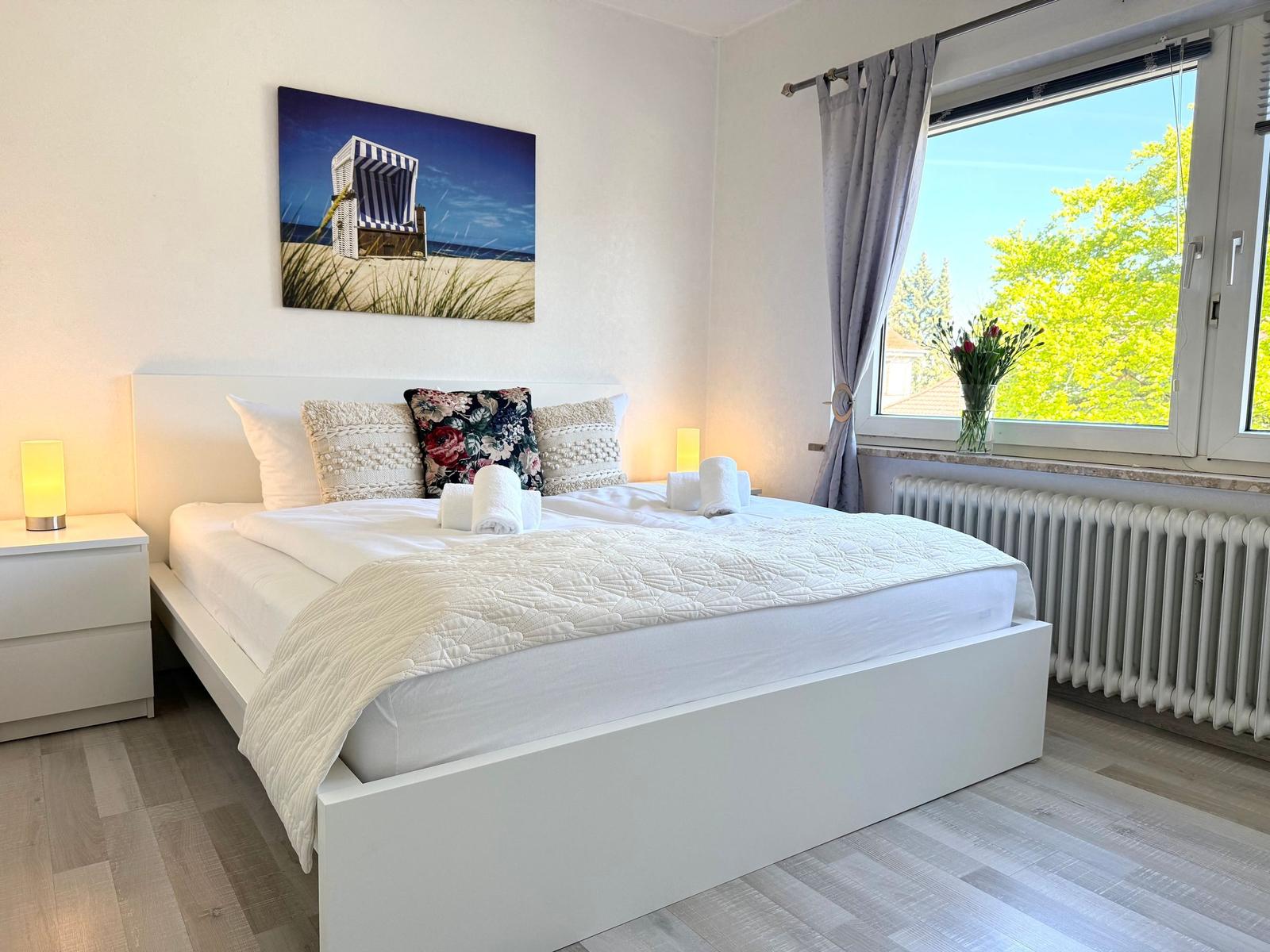 Schlafzimmer mit Doppelbett, Fenster und Wandbild