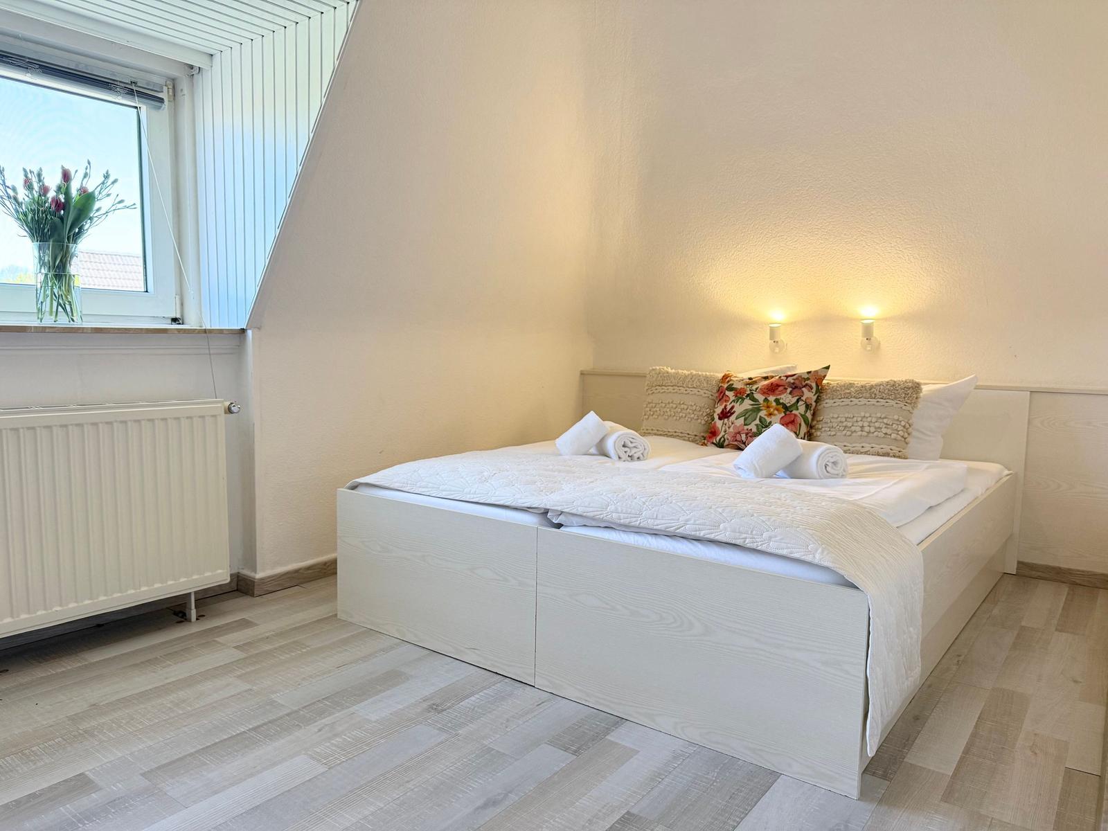 Schlafzimmer mit Bett, Fenster und Heizkörper