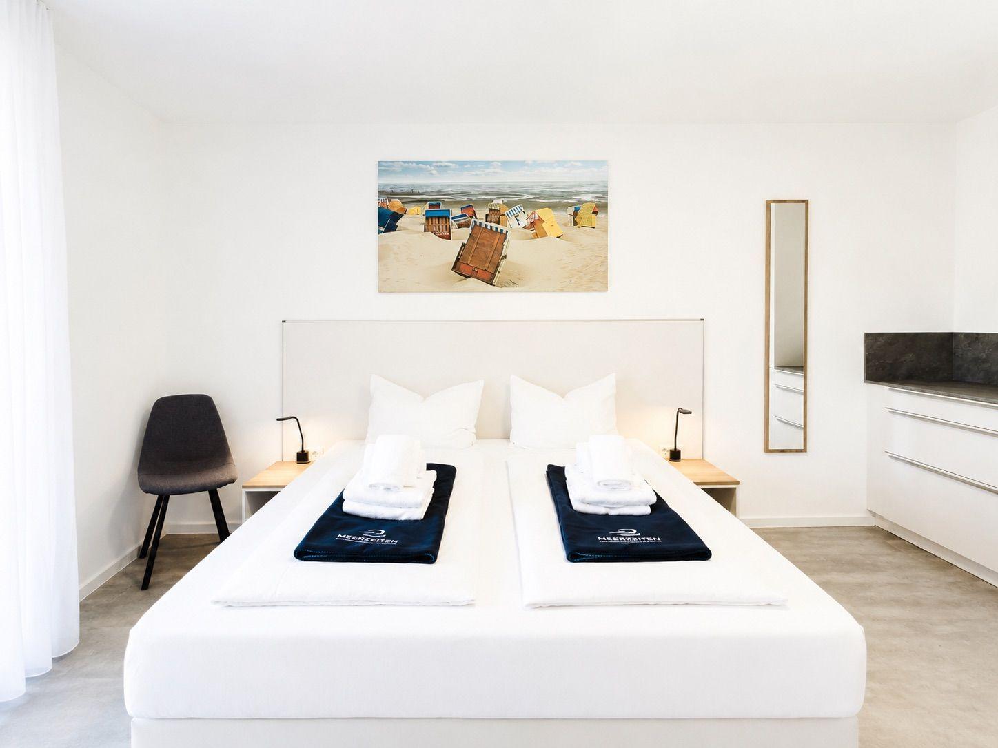 Schlafzimmer mit Doppelbett, Wandbild und Spiegel
