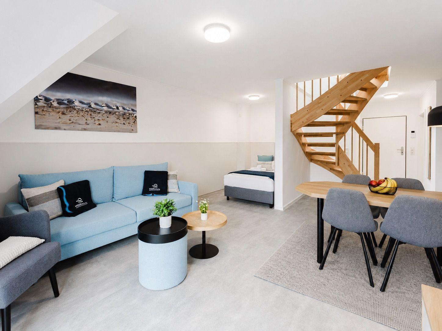 Wohn- und Essbereich mit Schlafzimmer und Holztreppe