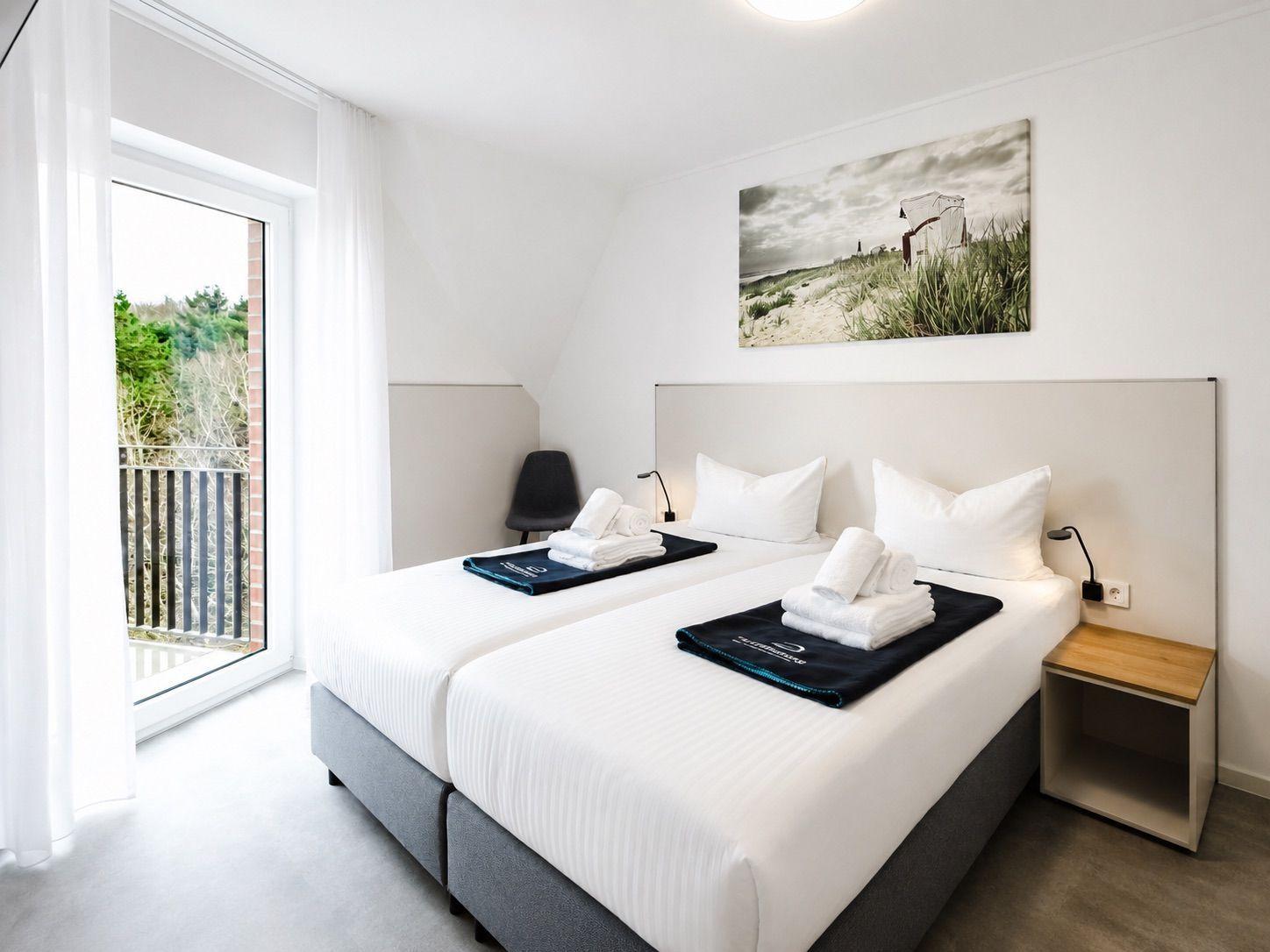 Schlafzimmer mit Doppelbett, Balkon und Wandbild.