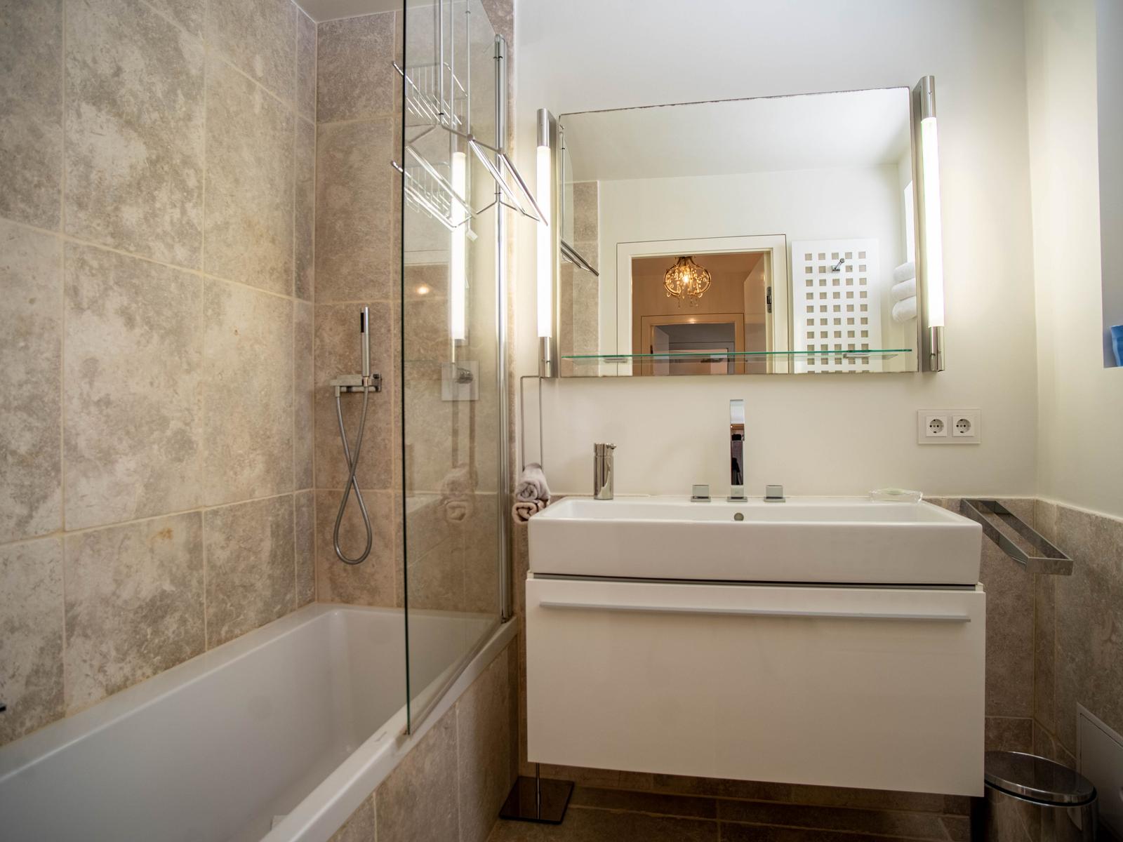 Bad mit Dusche, Badewanne und Waschbecken mit Spiegel