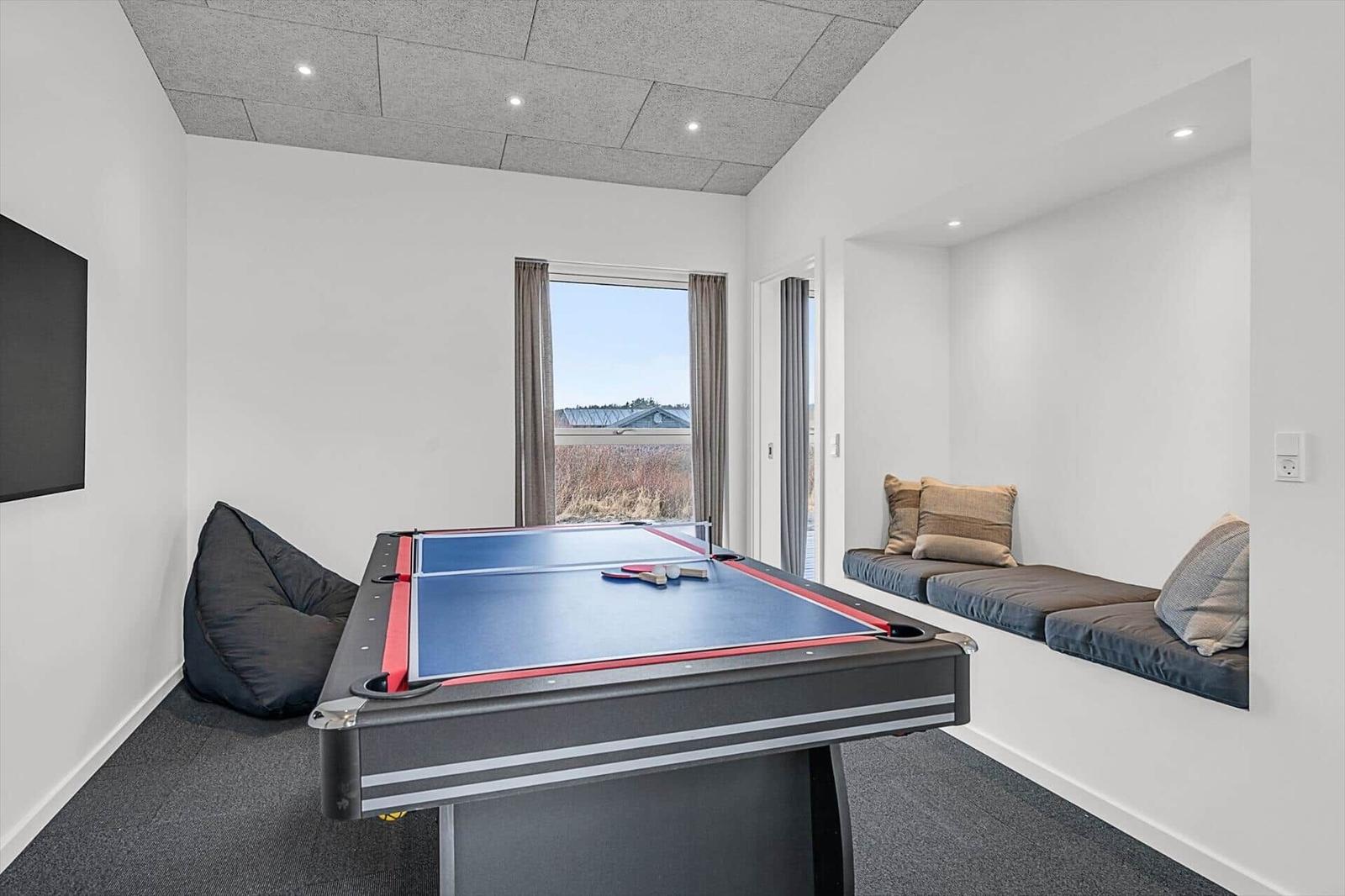Raum mit Tischtennisplatte, Sitznische und Fensterblick
