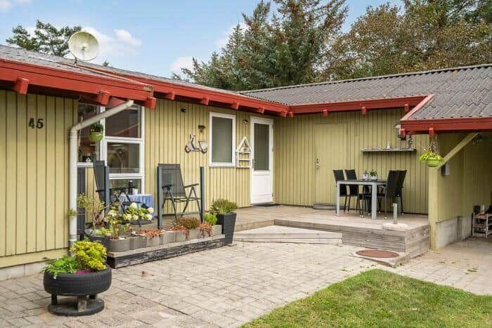 Haus mit Terrasse, Garten und Sitzgelegenheiten. Außenbereich mit Tisch und Stühlen.
