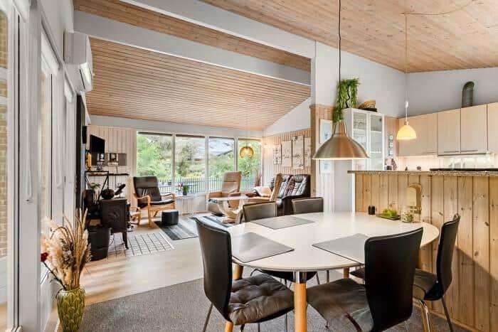 Essbereich mit runden Tisch und Stühlen. Küche und Wohnzimmer im Hintergrund.