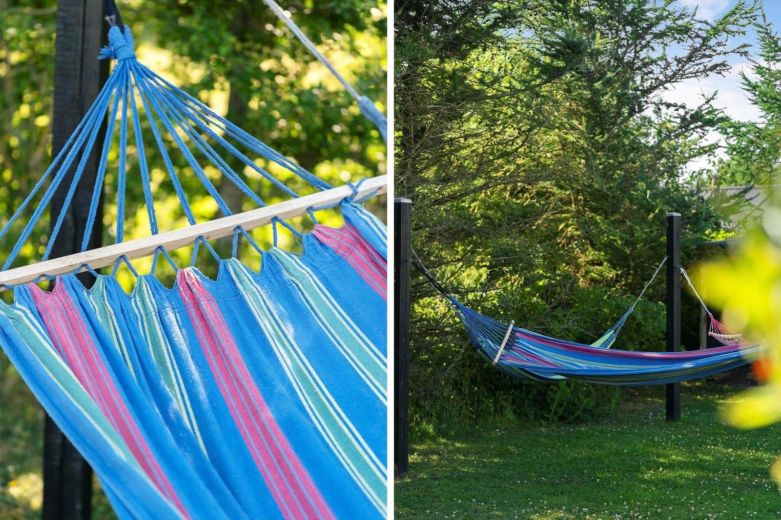Blauer Hängematten mit Streifen in Garten unter Bäumen
