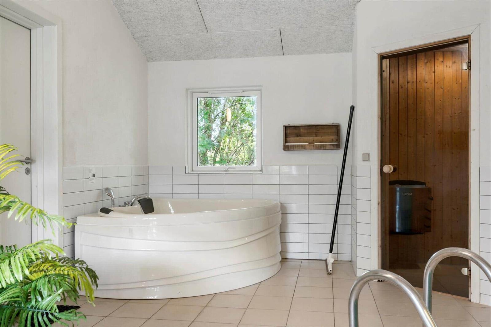 Bad mit Whirlpool, Fenster, Holztür und Pflanze