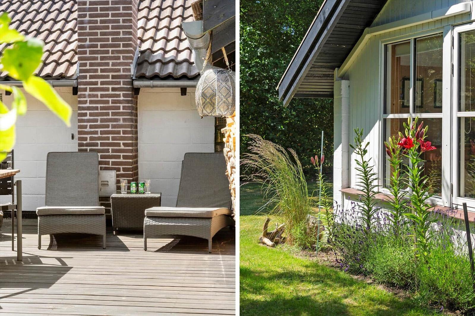 Terrasse mit zwei Liegestühlen und Grill. Garten mit Blumen und Gras.